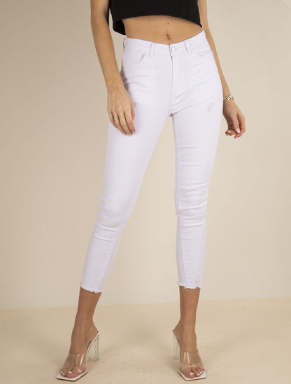 Jean 7/8 con detalles de desgaste y bordes deshilachados. - blanco